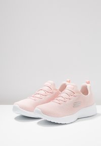 Jasnoróżowe sportowe buty z oddychającą cholewką z siateczki, elastycznymi sznurowadłami i białą gumową podeszwą; z ozdobą w postaci srebrnego logo.