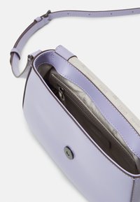 Violetti nahkainen olkalaukku, jossa on sileä pinta. Varustettu etuosan läppäkiinnityksellä ja vaaleanbeige sisävuori, jossa on vetoketjullinen tasku.