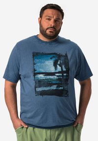 Modré bavlněné tričko s grafickým potiskem plážové scény se palmou, rámované černými štětcovými tahy, a kulatým výstřihem.