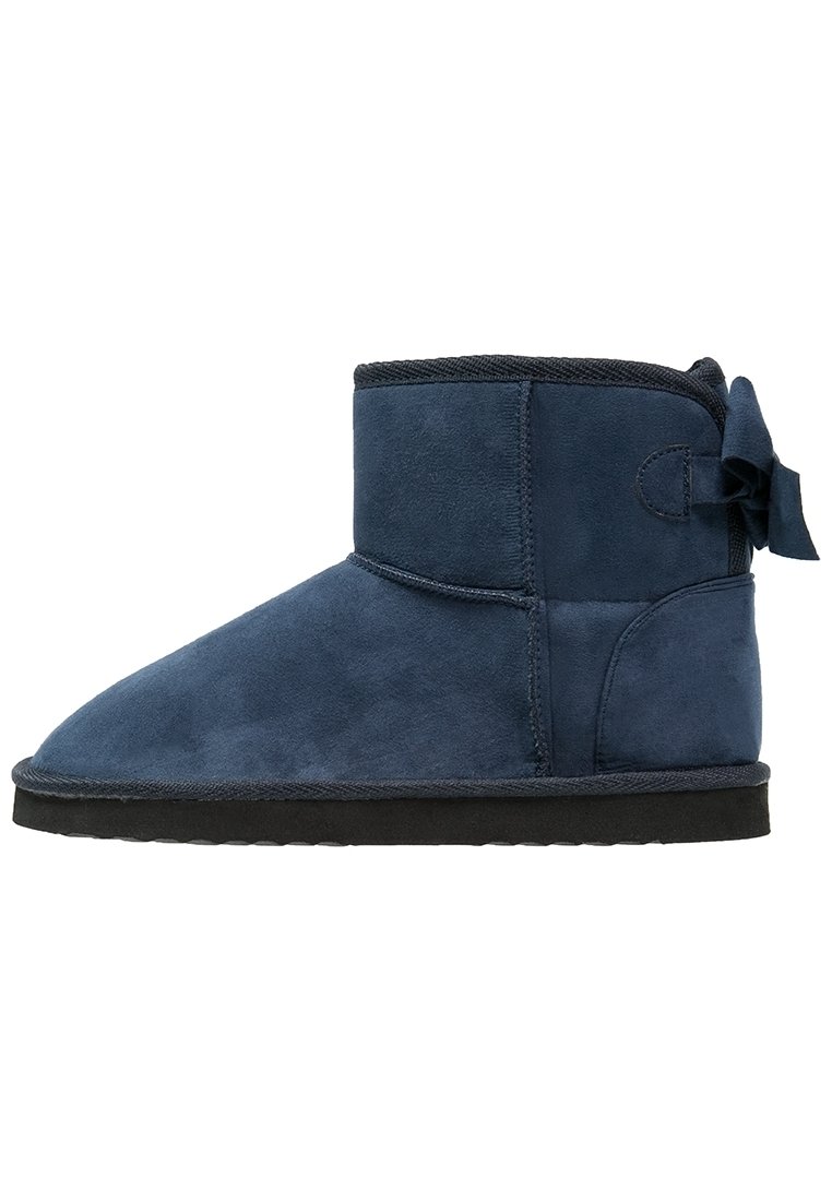 Botas de ante azul marino hasta el tobillo con punta redondeada, suela de goma negra y un lazo decorativo en el lateral. Textura suave y diseño de altura media.