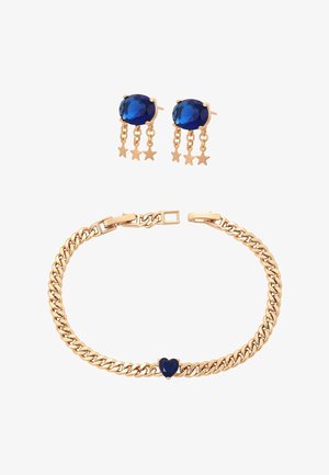 Goldene Gliederarmband mit einem blauen herzförmigen Stein und passenden Ohrringen mit blauen ovalen Steinen und sternförmigen Anhängern.