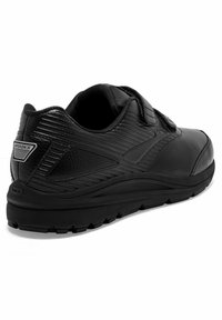 Schwarzer Sportschuh mit einer strukturierten Sohle aus Synthetik, verstellbarem Riemen und dicker Gummisohle. Mit gerilltem Design und Logodetail an der Ferse.