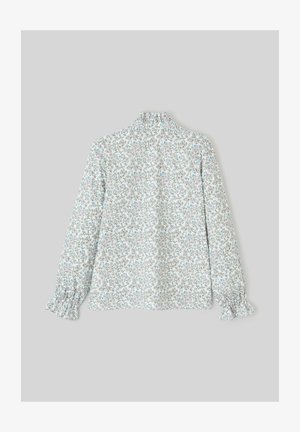 Blouse à manches longues en tissu léger avec un motif floral délicat, dotée de poignets volantés et d'un col montant. Fond principalement blanc.