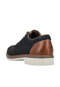 Marineblaue und braune Lederschuhe mit perforierter Textur, runder Zehenform, weißer Sohle und kontrastierenden Stichdetails an der Ferse.