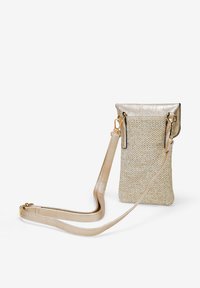 Pequeña bandolera hecha de tejido trenzado en un tono dorado, con una tapa metálica, correa ajustable y un diseño minimalista.