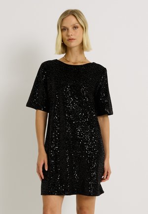 Vestido mini negro de lentejuelas con un corte holgado, mangas cortas y escote redondo. Textura suave realzada por lentejuelas reflectantes en todo el diseño.