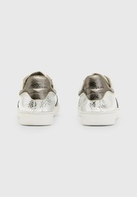 Silver and white sneakers with a textured, reptile-patterned finish, round toe, and contrasting black accents on a white sole. Plain heel.