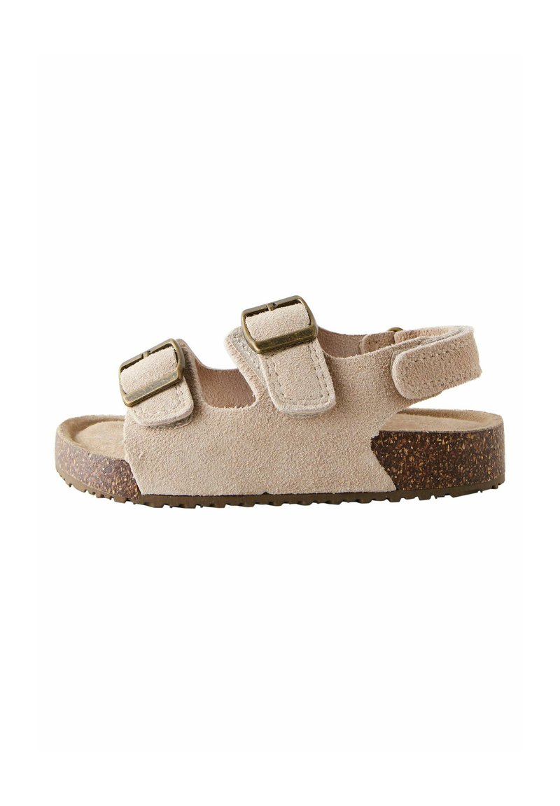 Beige suede sandal with cork sole, two adjustable buckle straps, and a velcro ankle strap on a white background.