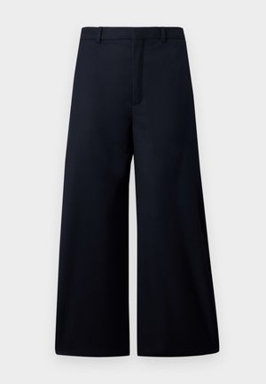 Weite Hosen in dunklem Marineblau, aus einem glatten Stoff gefertigt. Mit einem flachen Taillenbund, einer vorderen Bügelfalte und ohne sichtbare Hardware oder Muster.