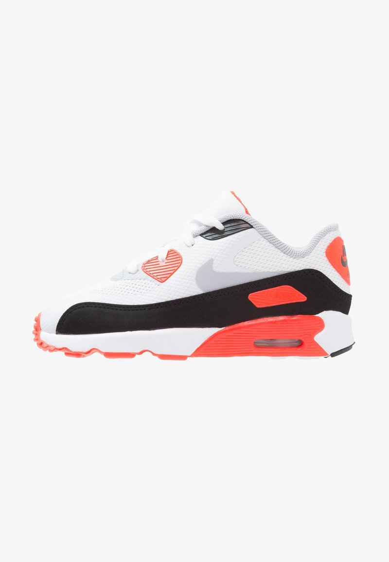 White and black athletic sneaker with orange accents, mesh upper, rubber outsole, and distinctive Air Max cushioning design.