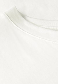 Cotton crewneck t-shirt i lys creme, med en glat tekstur og synlig ribbet krave med pæne sting langs kanterne.