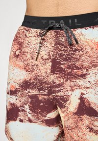 Herren Badehosen mit einem mehrfarbigen Felsenmuster, elastischem Bund und Kordelzugverschluss. Der Stoff hat eine glatte Textur.
