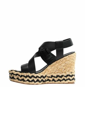Sandalo con zeppa in pelle nera con cinturini incrociati e suola platform in corda intrecciata con motivo nero e color cuoio naturale.