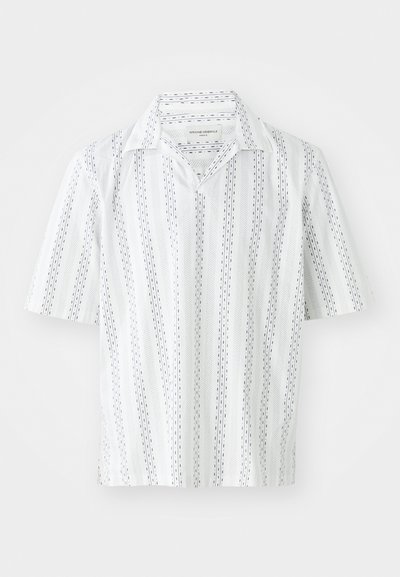 Lühikeste varrukatega särk valgest kangast, millel on peened tumesinised vertikaalsed triibud ja täpilised mustrid. Sellel on klassikaline krae ja lõdvem sobivus.