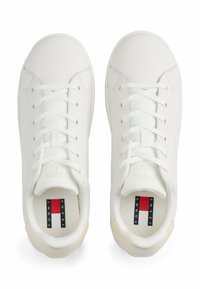 Sneakers blancs avec une tige synthétique lisse, bout rond, fermeture à lacets et logo sur la semelle intérieure. Semelles de couleur claire avec des accents texturés.