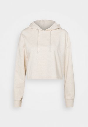 Hellbeiges, kurzes Hoodie mit langen Ärmeln, Kordelzugkapuze und gerippten Bündchen, gezeigt vor einem schlichten Hintergrund.