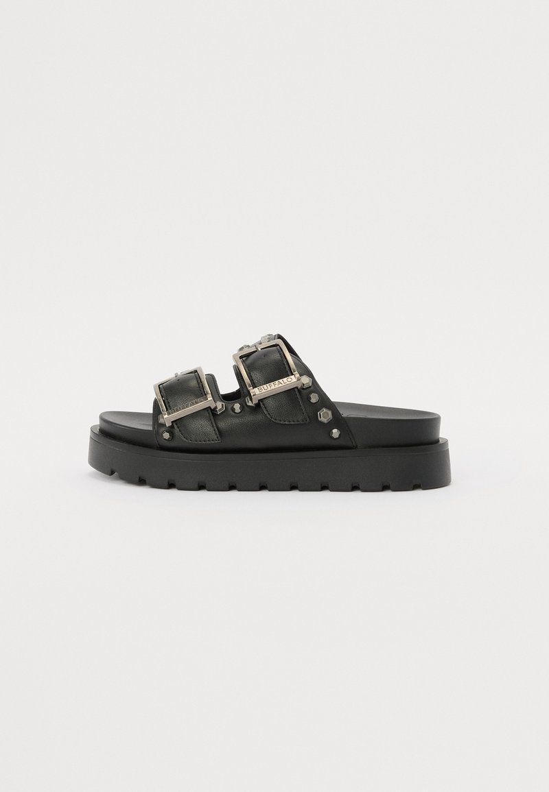 Svarte lær-sandaler med to justerbare spenner, nagleprydder og en tykk svart plattformsåle.