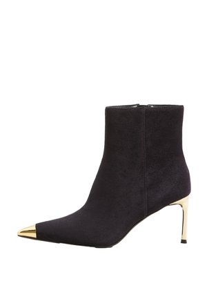 Black suede ankle boot with pointed gold metallic toe cap and slim gold stiletto heel.