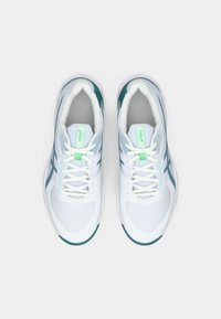 Witte sportschoenen met blauwgroene accenten, lichtgewicht meshstof, ronde neus en een goed dempende zool. Voorzien van witte veters en een groen logo op de tong.