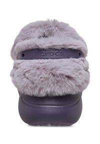 Paarse Crocs-clogs met een fluffy lavendelkleurige bontband over de bovenkant, met een gestructureerde rubberen zool en de merknaam "crocs" in reliëf.