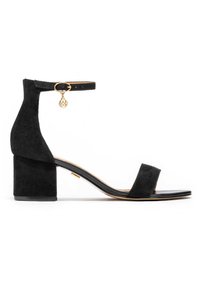 Must musta bloki kontsa sandaalid ankle strap'iga, kuldse detailiga, avatud varvasega ja lamedal tallal. Omab minimalistlikku disaini ja siledat tekstuuri.