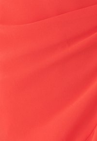 Heldere koraalkleurige stof met een zachte, gestructureerde oppervlakte, voorzien van soepele plooien en een subtiele glans, ideaal voor kleding of accessoireontwerpen.