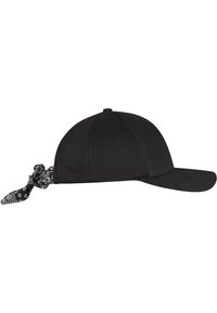 Căciulă neagră din material, cu o vizieră curbată și curea ajustabilă. Accesoriu tip bandană legat în spate cu un model floral alb.