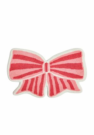 Tapis en forme de nœud rayé rose et rouge avec bord blanc sur fond blanc uni.