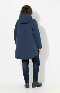 Cappotto impermeabile blu navy con cappuccio, caratterizzato da una linea dritta e una lunghezza intermedia. Tessuto testurizzato e spalle senza cuciture.