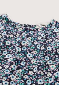 Stof met bloemenpatroon in marineblauw met witte, roze en groene bloemen. Samengeschoven ontwerp met een ronde halslijn en een knoopsluiting.
