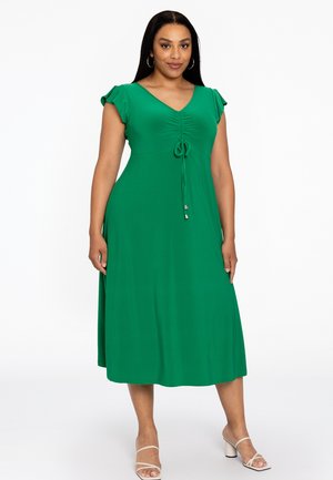 Groene jurk tot de knie met korte, vloeiende mouwen, V-hals, centrale plooien, verstelbare strikdetail op de taille, gladde stoftextuur.