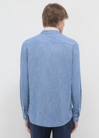 Chemise bleu à manches longues avec un motif texturé, des poignets à boutons, un col blanc contrastant, une ourlet incurvé et une carrure droite au dos.