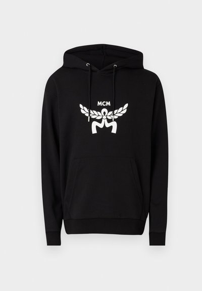 Sort hoodie lavet af en bomuldsblanding, udstyret med en frontkangaroo lomme, snore og et stort hvidt MCM-logo med vinger design.
