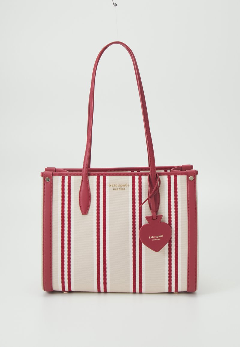 Sac cabas rectangulaire avec rayures verticales crème et rouges, anses en cuir rouge, et une étiquette rouge en forme de cœur avec la marque Kate Spade.