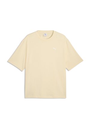 T-shirt beige manches courtes Puma avec col rond et petit logo blanc Puma sur la poitrine gauche, présenté à plat sur fond blanc.