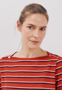 Rødstribet t-shirt med bådhals, der har horisontale hvide og marineblå striber, samt dekorative guldknapper ved skulderen.