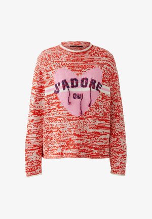 Rood-witte gebreide trui met een grote roze hart en de tekst "J'ADORE oui" aan de voorkant, voorzien van lange mouwen en een ronde halslijn.