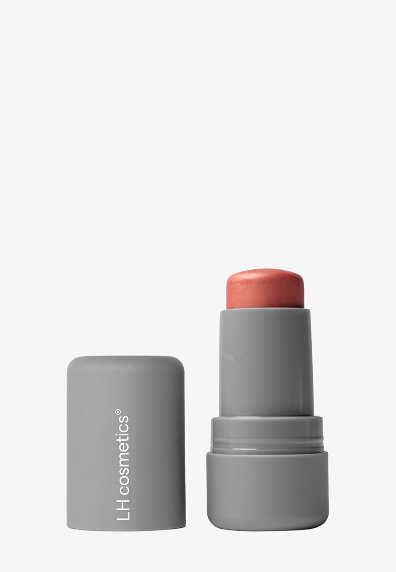 Rouge à lèvres LH Cosmetics mat gris avec une teinte nude rosée, bouchon retiré et placé à côté du tube sur fond gris.