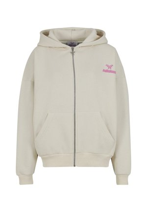Haut à capuche zippé de couleur crème avec poches avant et un petit logo de papillon rose ainsi que le texte "felicious" sur le côté gauche du torse.