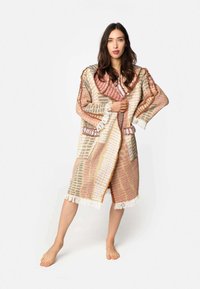 Kapotová, tkaná kimono v teplých odtieňoch ružovej, béžovej a šedej; obsahuje strapce a dve nášivkové vrecká. Mäkko textúrovaná tkanina.