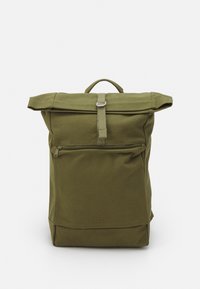 Green canvas backpack with a roll-top design, zippered front pocket, and a logo accent at the bottom. Features a top handle and sturdy straps.