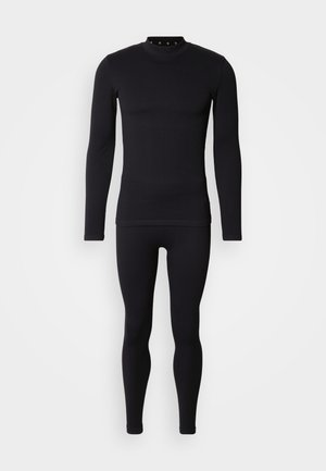 Czarny prążkowany komplet z długim rękawem i legginsami, z wysokim kołnierzem i dopasowanym krojem, wykonany z elastycznego materiału dla zapewnienia komfortu.