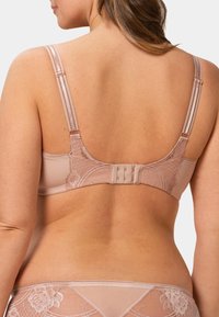 Světle růžová podprsenka s krajkovými doplňky, nastavitelnými ramínky a zapínáním na háček a očko vzadu. Hladká textura a tvarovaná silueta.