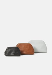 Three zippered leather pouches in black, brown, and light gray, featuring a textured finish and a rounded shape, with subtle branding on the front.