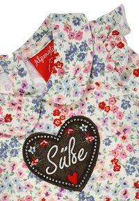 Stoff mit Blumenmuster in Weiß, mit Rüschenkragen, herzförmigem braunem Fleck mit "Süße" in Weiß, verziert mit Perlen und floralen Stickereien.