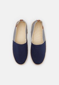 Blaue Canvas-Slipper mit gestreiftem Textil-Obermaterial, gewebter Jute-Sohle und braunen Lederakzenten an der Ferse.
