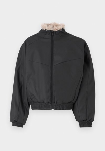 Μαύρο τζάκετ bomber με κλείσιμο φερμουάρ και ελαφριά συνθετική γούνα στον γιακά. Διαθέτει ελαστικές μανσέτες και κάτω μέρος, λεία υφή και δομημένο σχέδιο.