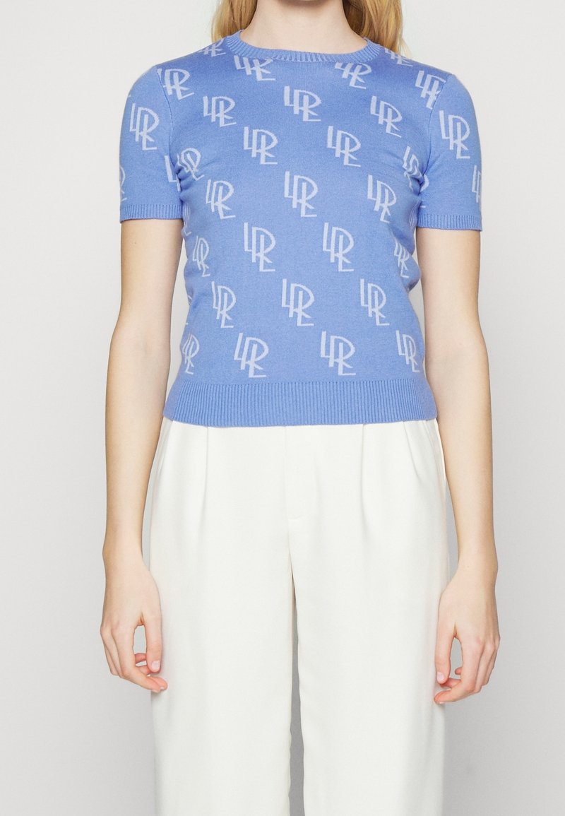 Maglietta corta blu con maniche corte caratterizzata da un motivo a logo bianco ripetuto, colletto e orlo a coste, design aderente, realizzata in un morbido tessuto a maglia.