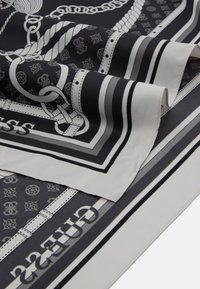 Foulard en soie noir et blanc présentant des motifs géométriques, des motifs de corde et des rayures uniformes. Les bords sont soigneusement ourlés avec une texture lisse.