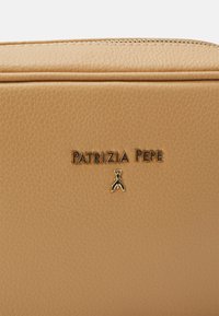 Skórzana kosmetyczka w kolorze brązowym z wytłoczonym logo "Patrizia Pepe" oraz ozdobnym złotym akcentem. Zamek błyskawiczny u góry. Tekstura powierzchni.